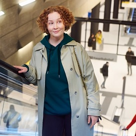 Frau fhrt Rolltreppe hoch