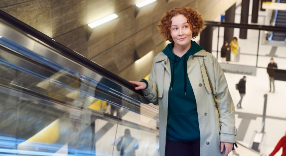 rothaarige Frau auf einer Rolltreppe