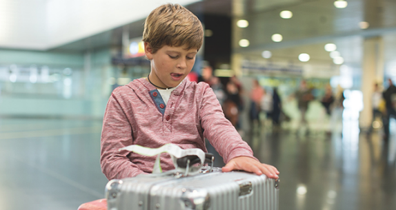 Junge mit einem Koffer am Flughafen