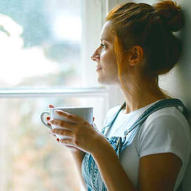 Junge Frau schaut aus dem Fenster