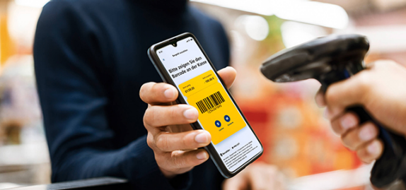 Mann zeigt Bargeld-Code an der Kasse