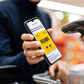 Mann mit einem Handy an der Kasse